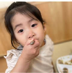 カメラ目線で美味しそうに給食を食べている園児の姿