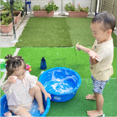 泡の入った水面機に入り水遊びをしている園児たち